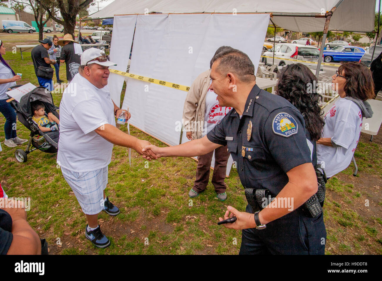 Eine Hispanic Mann grüßt ein Polizist bei einer Anti-Gewalt-Rallye in Santa Ana, CA, Stadtpark. Stockfoto