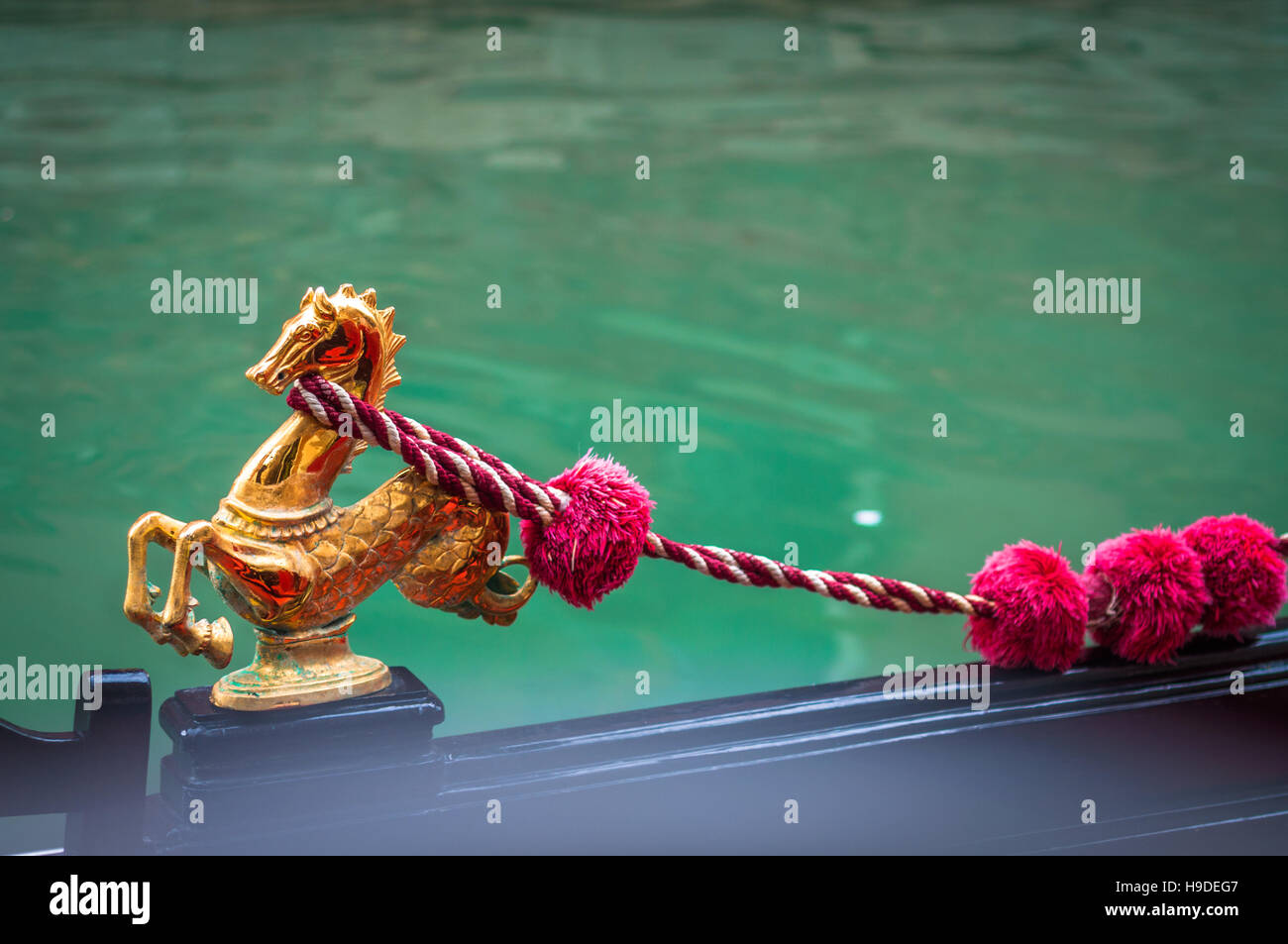 Goldenen Seepferdchen Ornament mit Pompons eine venezianische Gondel. Stockfoto