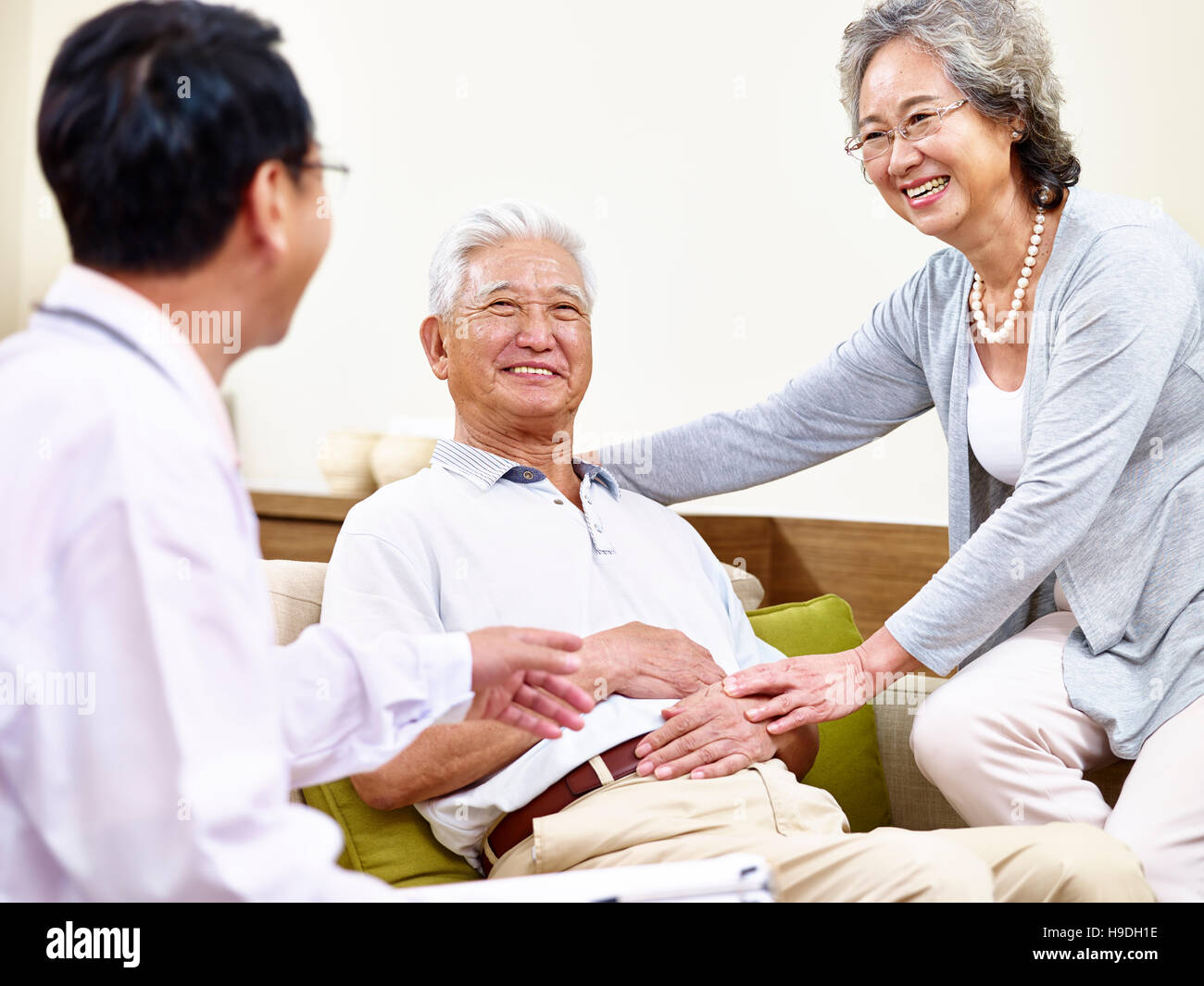 Senior asiatischen Patienten wird von seiner Frau und einen Hausarzt betreut Stockfoto