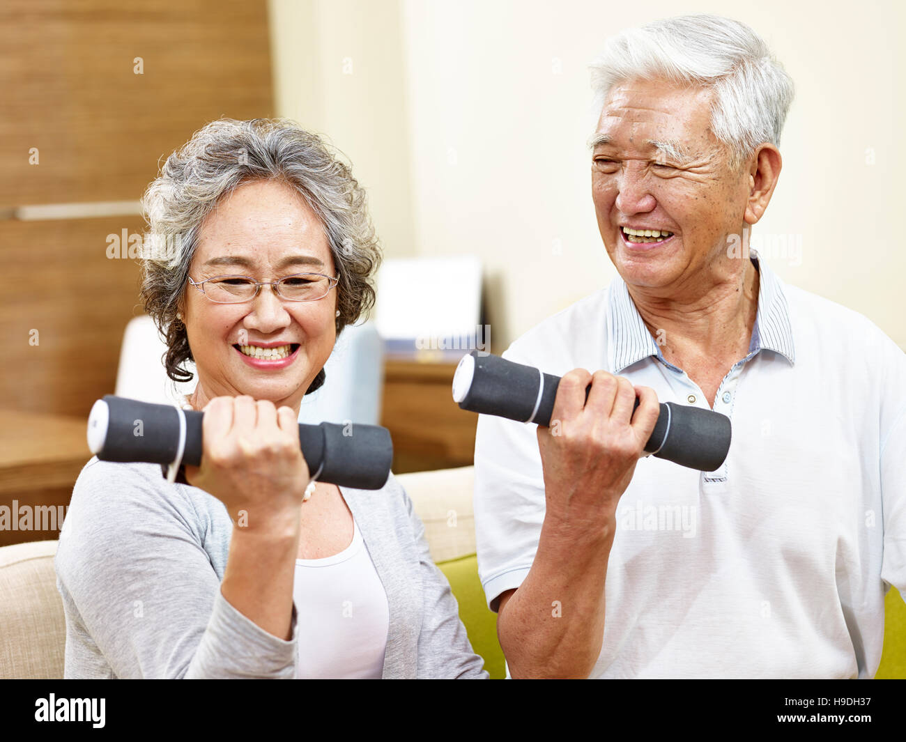 gerne älteres paar trainieren mit Hanteln, glücklich und lächelnd Stockfoto