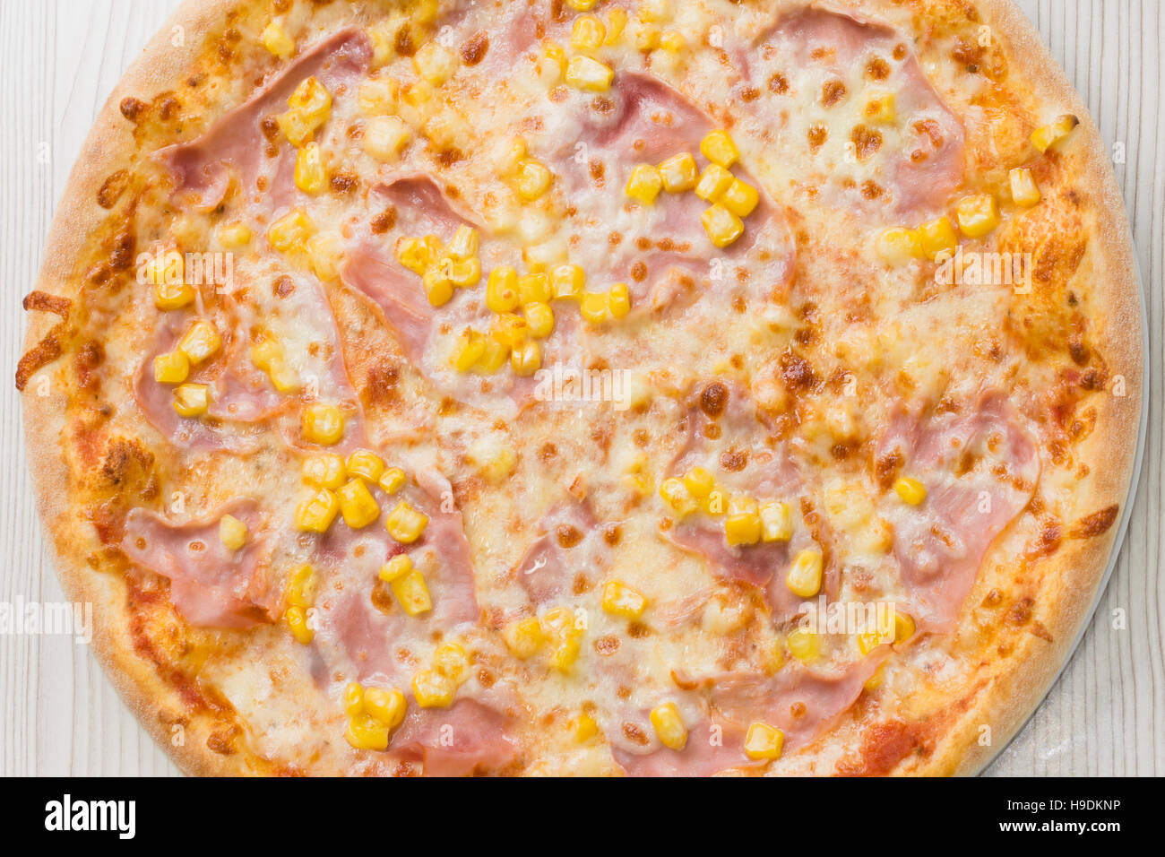 Pizza mit Schinken und Mais auf dem Tisch Stockfotografie - Alamy