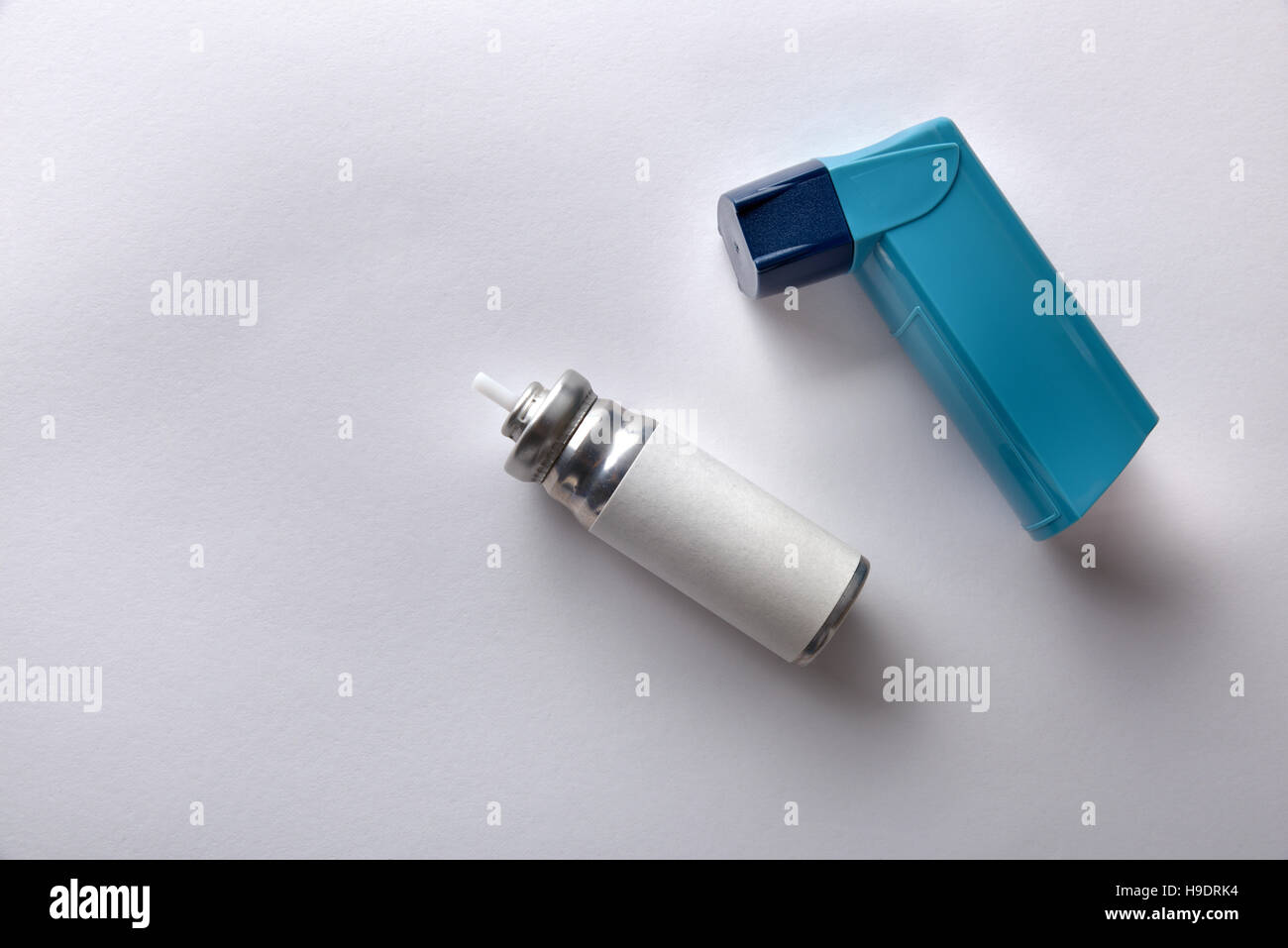 Patrone und blau Medizin Inhalator auf weißen Tisch. Ansicht von oben. Horizontale Komposition Stockfoto