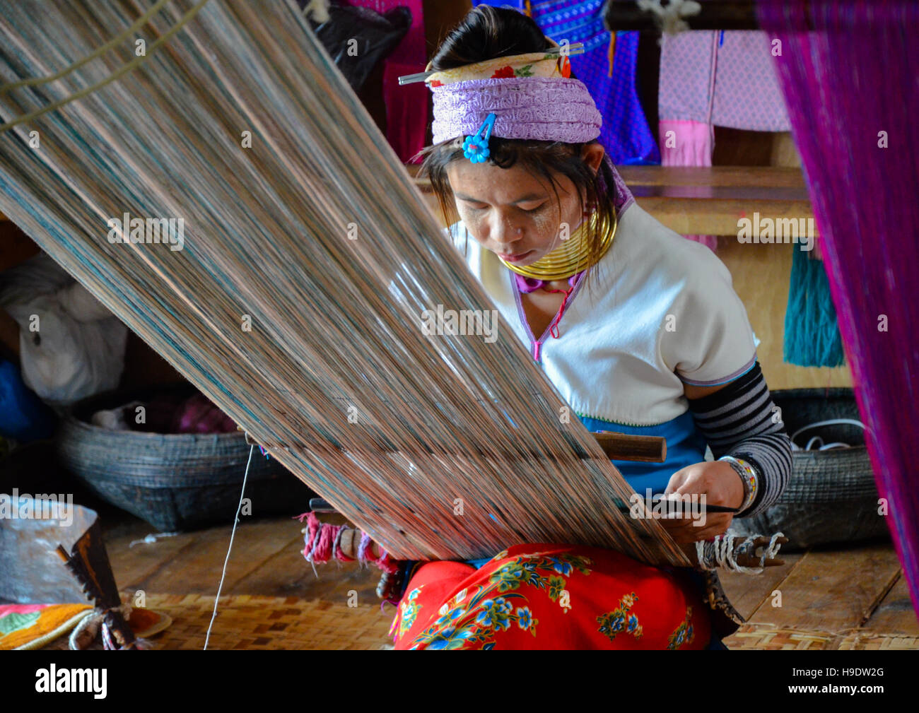 Padaung 'lange necked' Frau, die traditionelle Metallringe um den Hals tragen das Weben auf einem Webstuhl Stockfoto