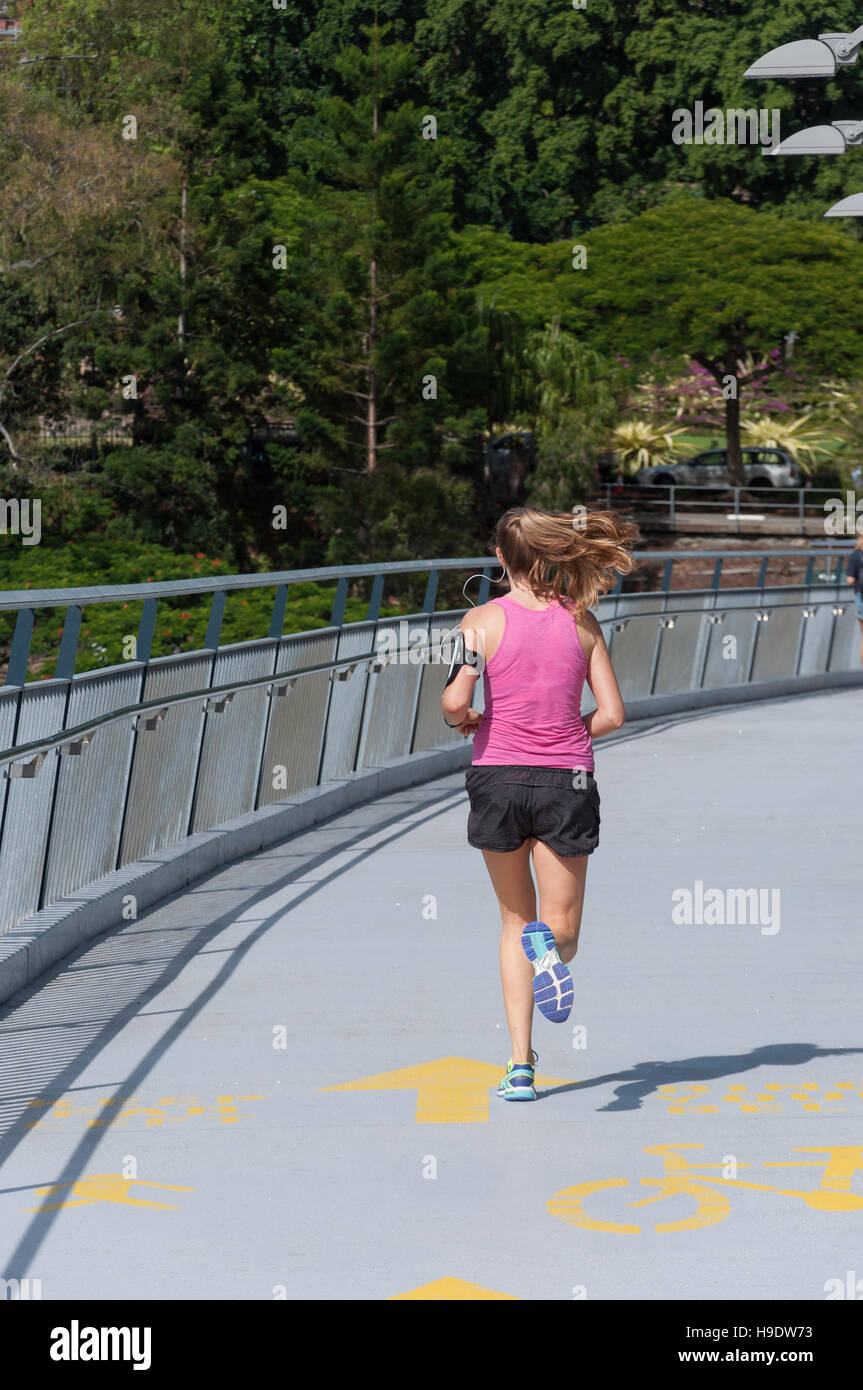 Junge weibliche Läufer Kurilpa Brücke über den Brisbane River in Brisbane City, Brisbane, Queensland, Australien Stockfoto