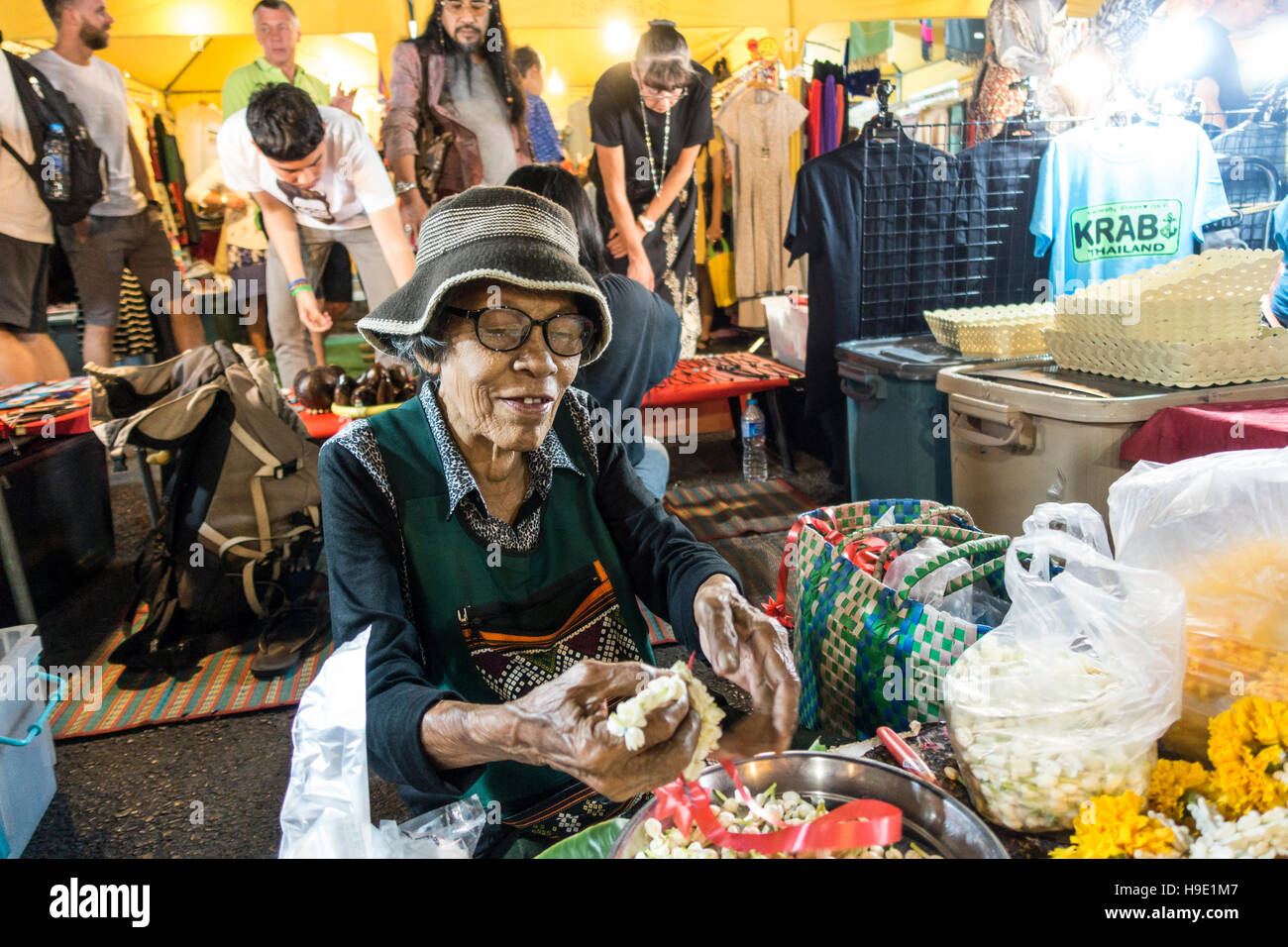 Alte Frau verkauft Thai-Frau, Blumen und Blumen Ketten an den Night Market, Krabi-Stadt, Provinz Krabi, Thailand Stockfoto