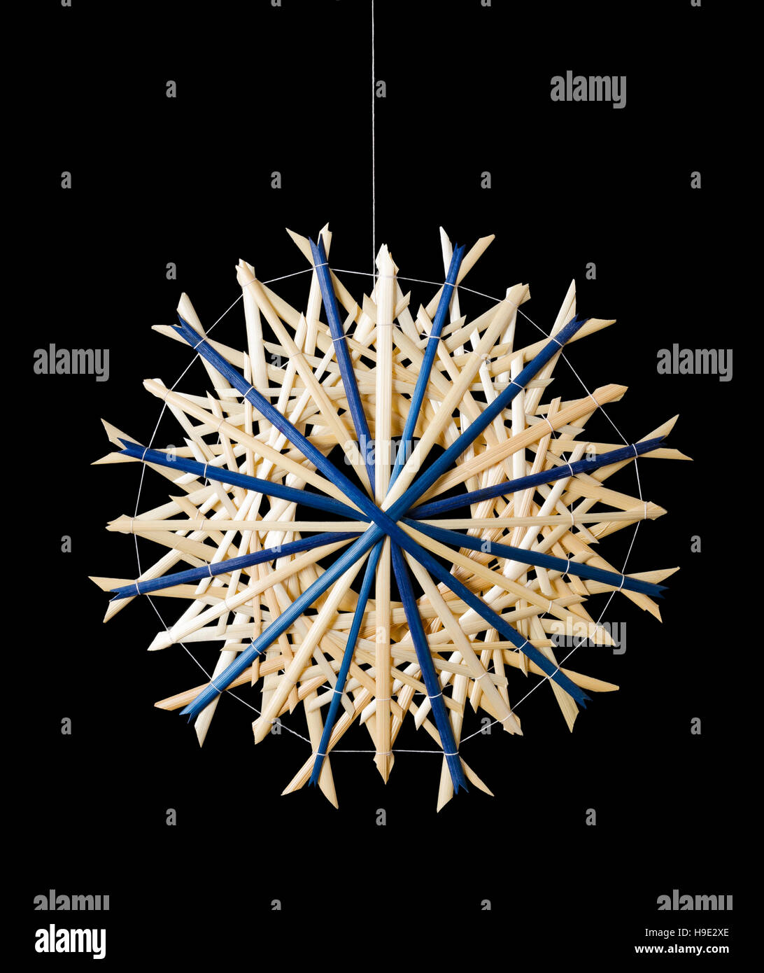 Blaue Stroh Sterne Weihnachtsdekoration auf schwarzem Hintergrund. Handgemachte Dekoration für Fenster, als Geschenk oder an den Weihnachtsbaum hängen. Stockfoto