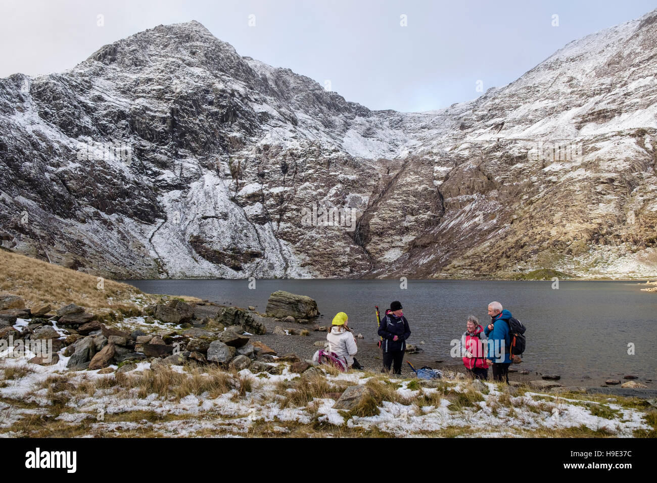 Wanderer von Glaslyn See unterhalb Mount Snowdon Gipfel mit Schnee im Winter ruht. Snowdonia National Park (Eryri). North Wales UK Großbritannien Stockfoto