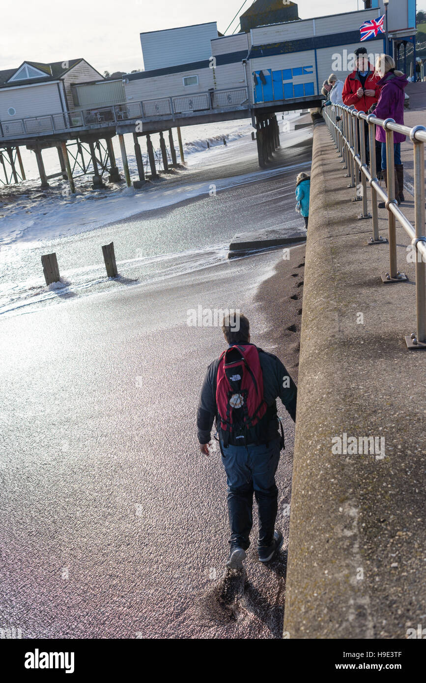 Teignmouth, Devon, UK. Ein Mann ruft seine Füße nass von einer Welle, nachdem wie weit sich die Flut verkennen gegangen war. Stockfoto