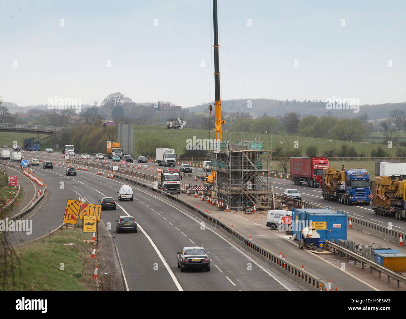 Bau einer neuen Brücke für die A46 über die Autobahn M40, Oxfordshire, Großbritannien. Schalung für Brückenpfeilern und Kran im zentralen Reservat. Stockfoto