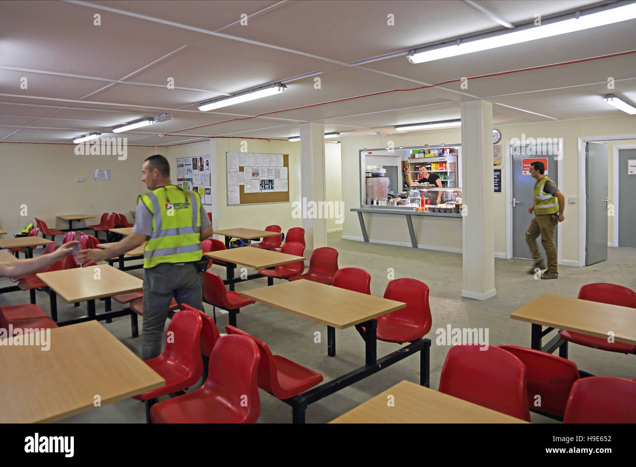 Innere der Leiharbeitnehmer Kantine auf einer großen Baustelle in London, Vereinigtes Königreich. Küche, Speisenausgabe und eine Sitzecke zeigt Stockfoto