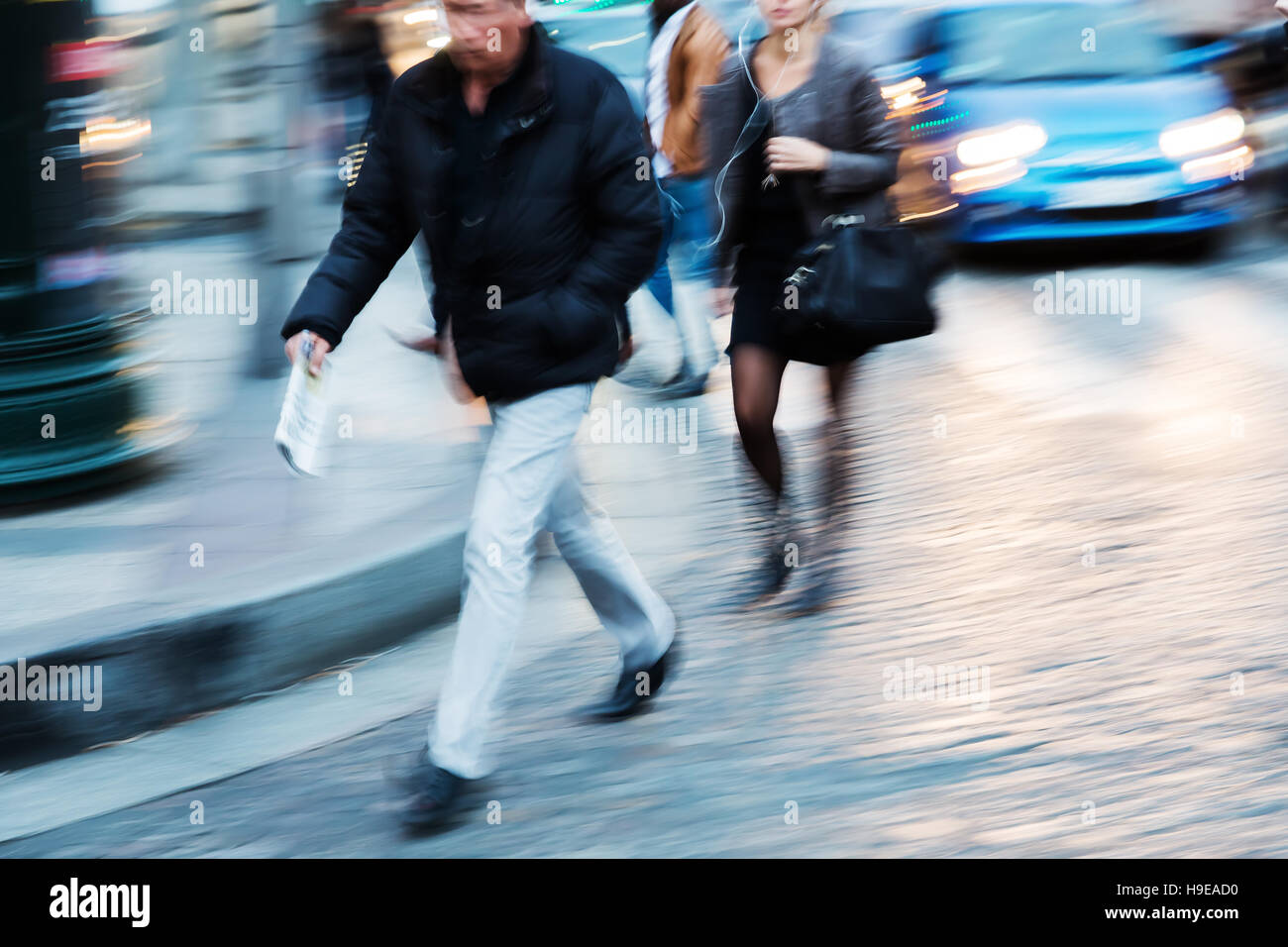 Menschen zu Fuß in die Stadt in der Abenddämmerung mit absichtliche Bewegung verwischen Stockfoto