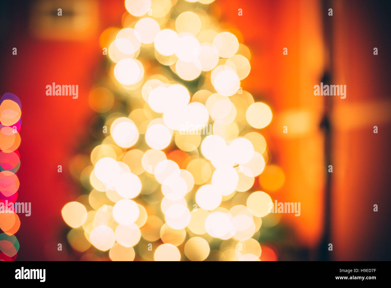 Schöne defokussiertem Hintergrund neues Jahr Zimmer mit geschmückten Weihnachtsbaum, Geschenke und Kamin mit dem glühenden Lichter bei Nacht. Die Idee für postca Stockfoto