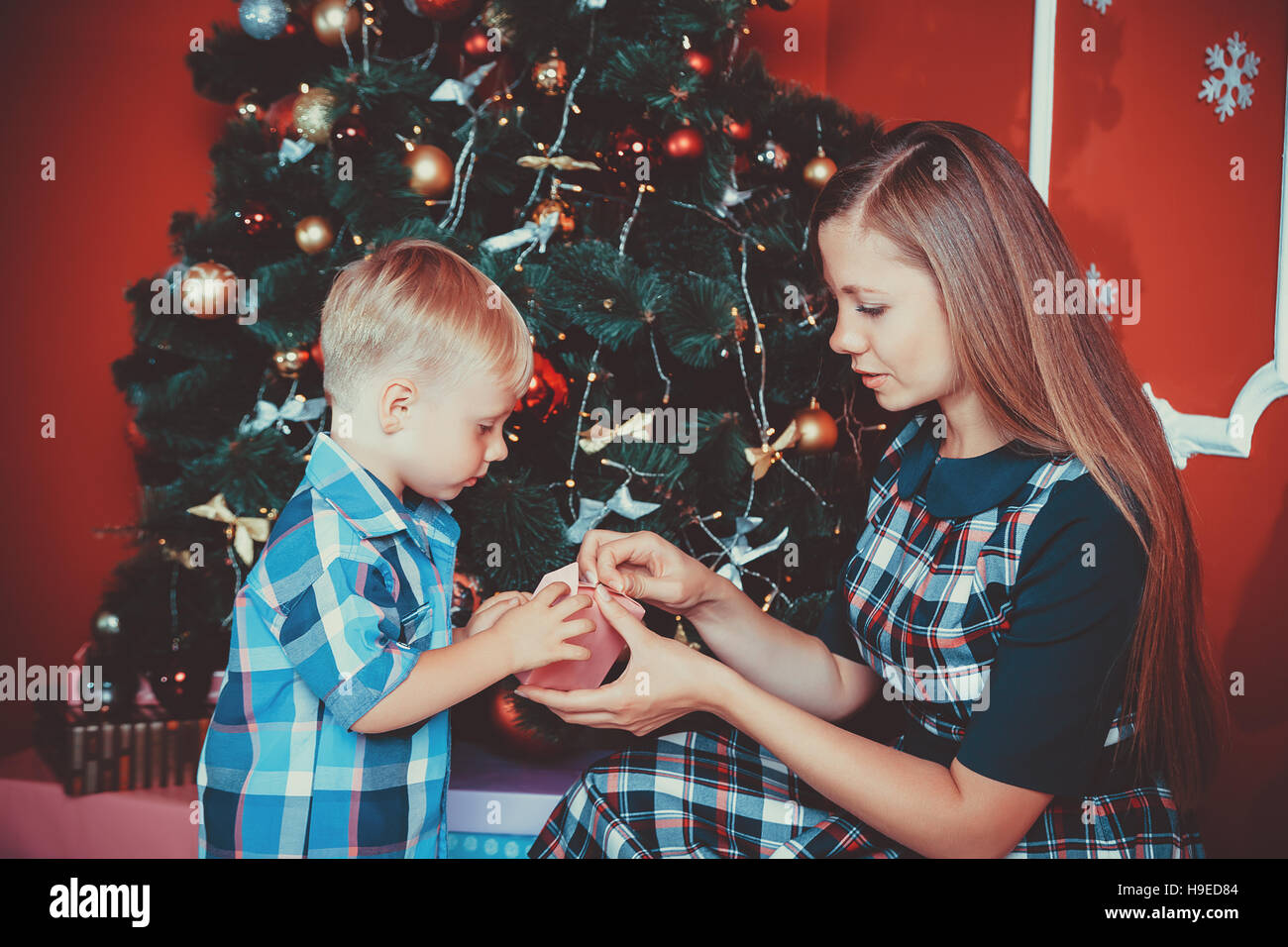 Schöne Portrait der glücklichen Mutter und Sohn auf dem Hintergrund der Weihnachtsbaum im neuen Jahr Zimmer mit Geschenken. Die Idee für Postkarten. Soft Focus.sh Stockfoto