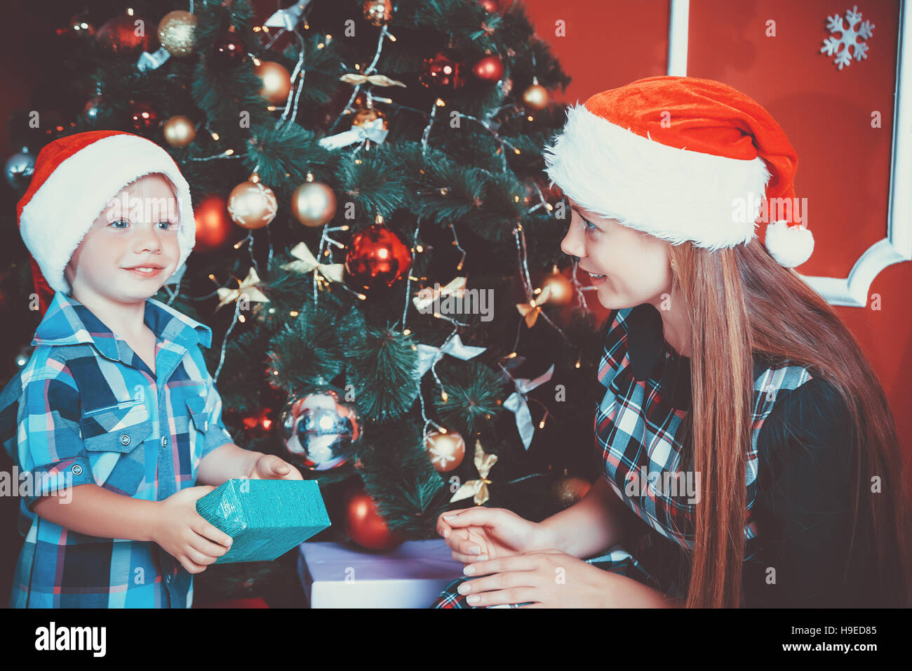 Schöne Portrait der glücklichen Mutter und Sohn auf dem Hintergrund der Weihnachtsbaum im neuen Jahr Zimmer mit Geschenken. Die Idee für Postkarten. Soft Focus.sh Stockfoto