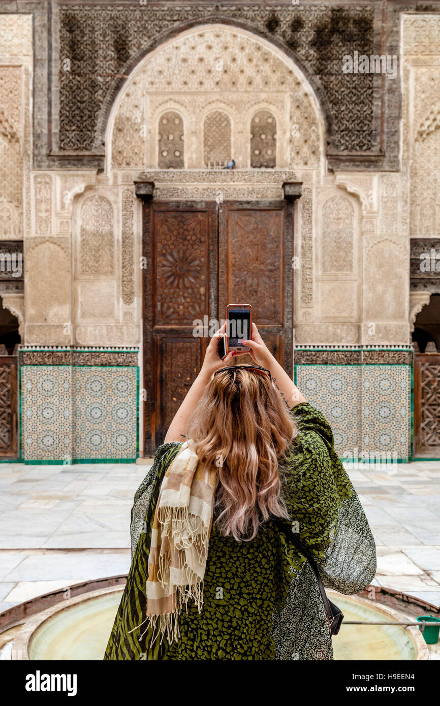 Eine weibliche Touristen nimmt A Foto mit A Smartphone In der Medersa Bou Inania, Fes el Bali, Fes, Marokko Stockfoto