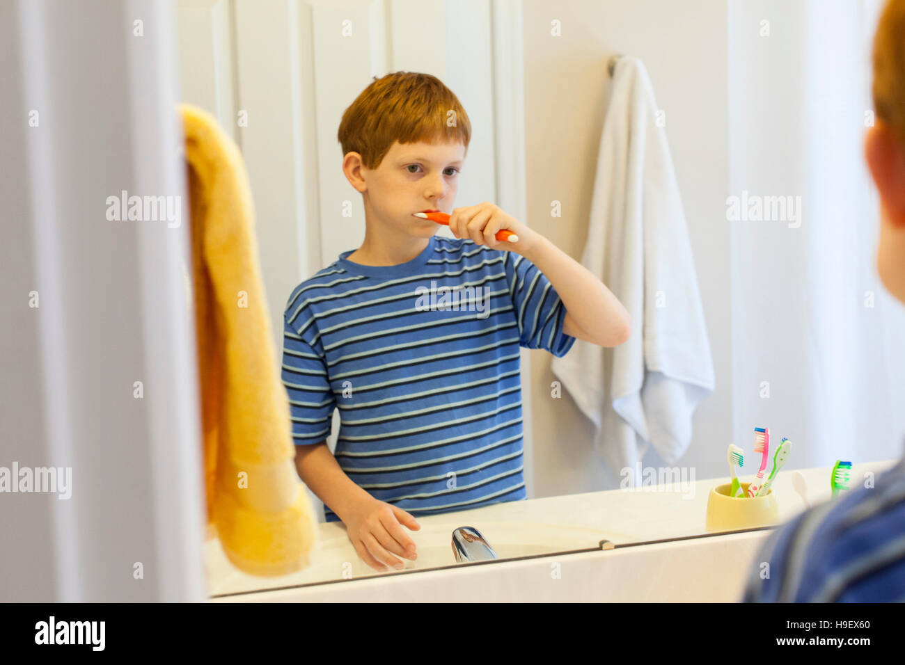 Reflexion des kaukasischen jungen Zähneputzen im Spiegel Stockfoto