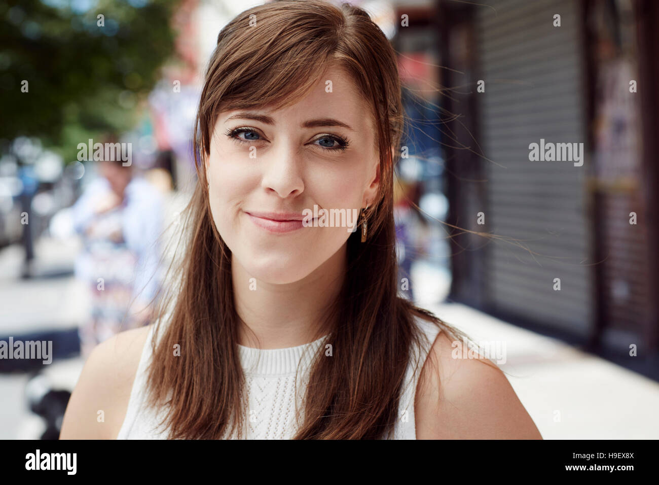 Kaukasische Frau lächelnd auf Stadt Bürgersteig Stockfoto