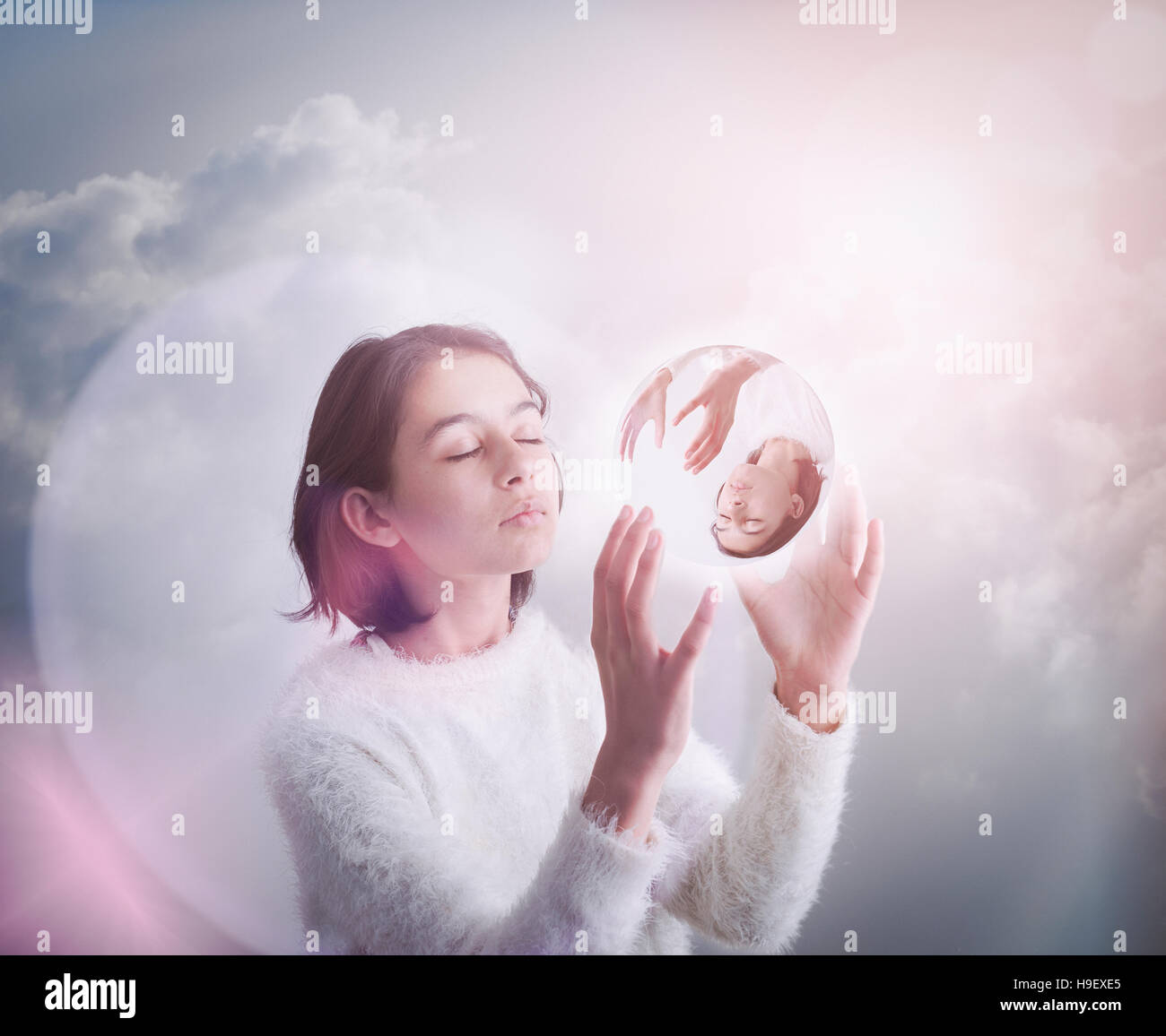 Gemischte Rennen Mädchen in den Wolken mit Glaskugel Stockfoto