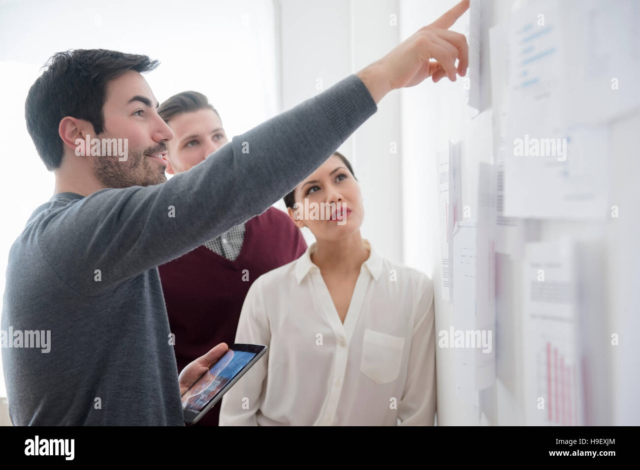 Business-Leute reden Papierkram an Wand Stockfoto