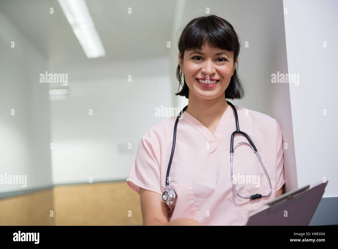Lächelnd Hispanic Krankenschwester hält Zwischenablage Stockfoto