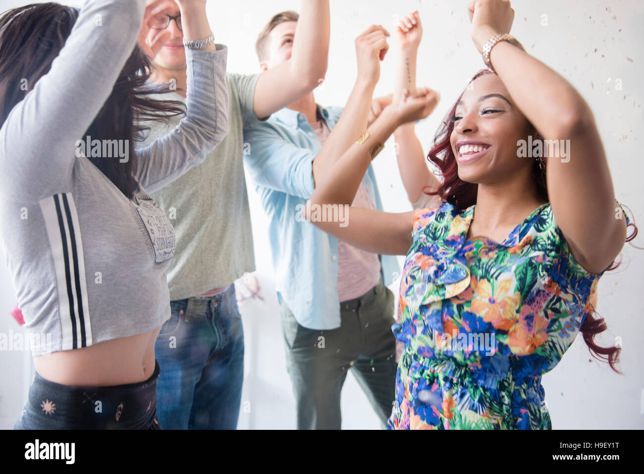 Freunde in Konfetti auf Party tanzen Stockfoto