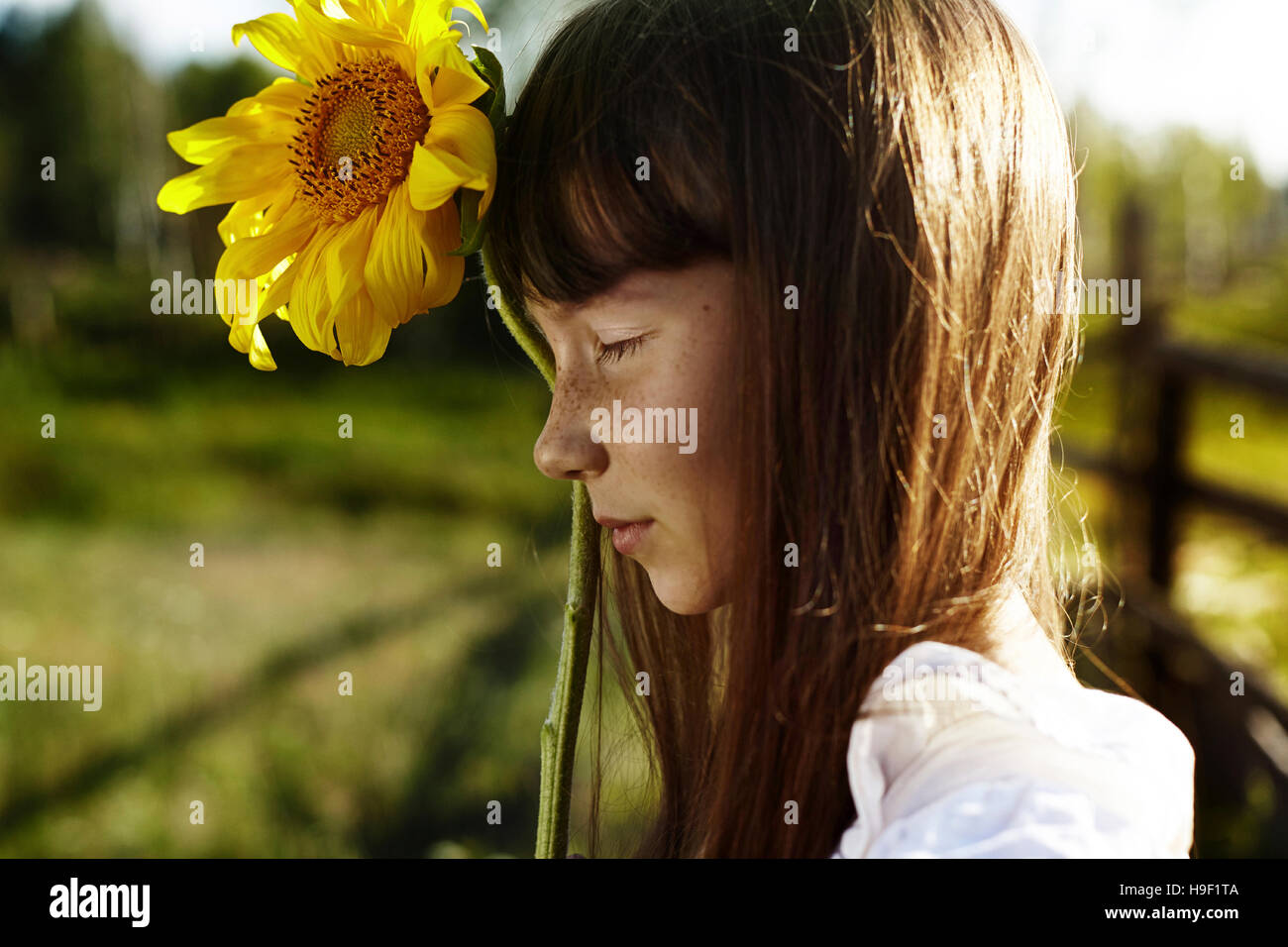 Profil von kaukasischen Girl mit Sommersprossen mit Sonnenblume Stockfoto