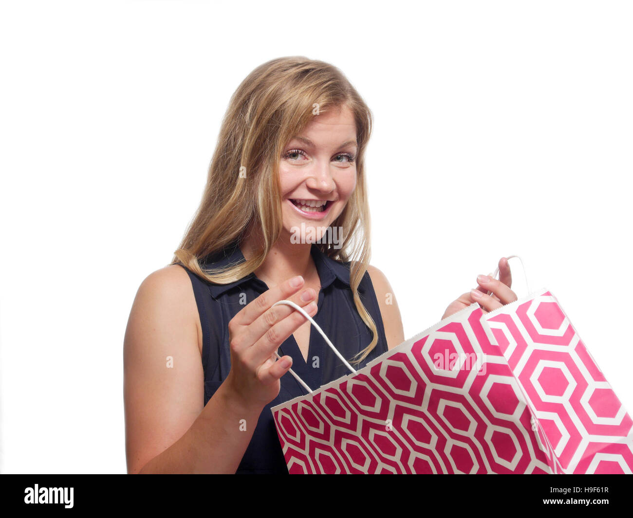 Eine junge Frau ist, öffnen Sie einen Einkaufskorb und lächelnd. Stockfoto
