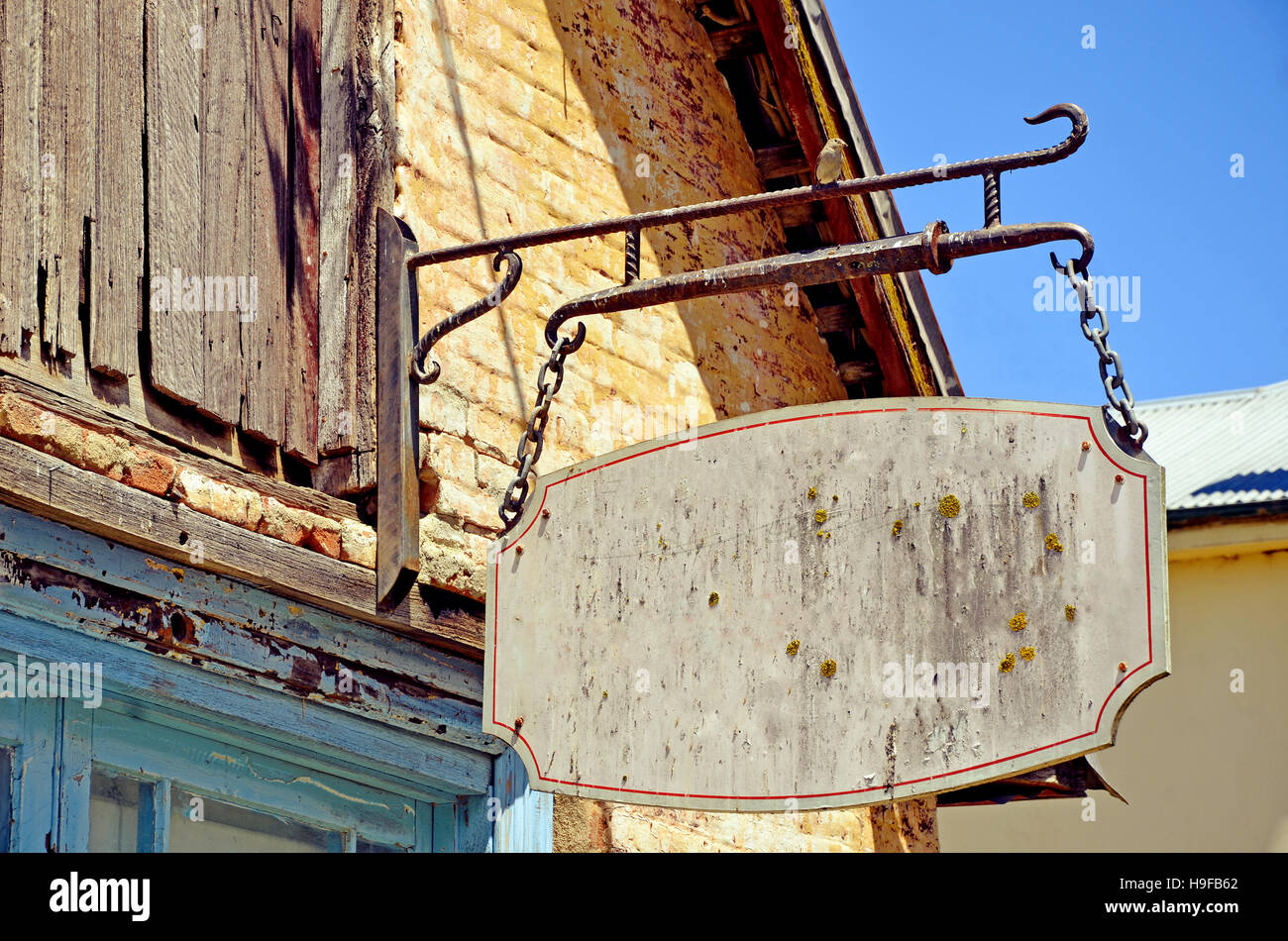 Vintage distressed rustikalere Zeichen hängen Flechten und Moos am Ladenfront des historischen Gebäudes bedeckt. Platz für Text zu kopieren. Stockfoto