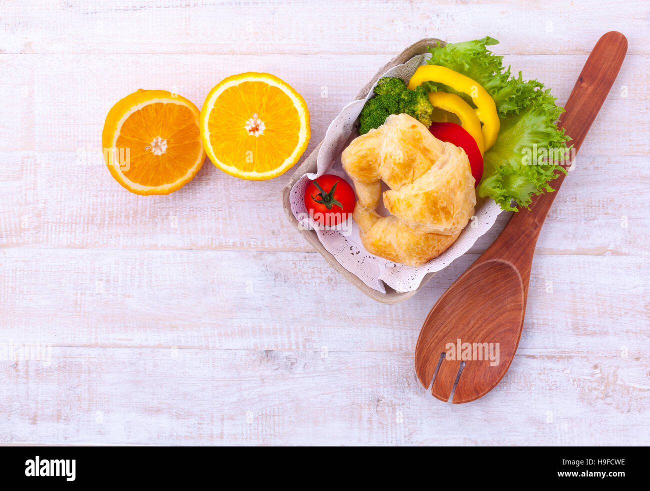 Saubere Lebensmittel Frühstück Croissant und Salat auf Holztisch. Stockfoto