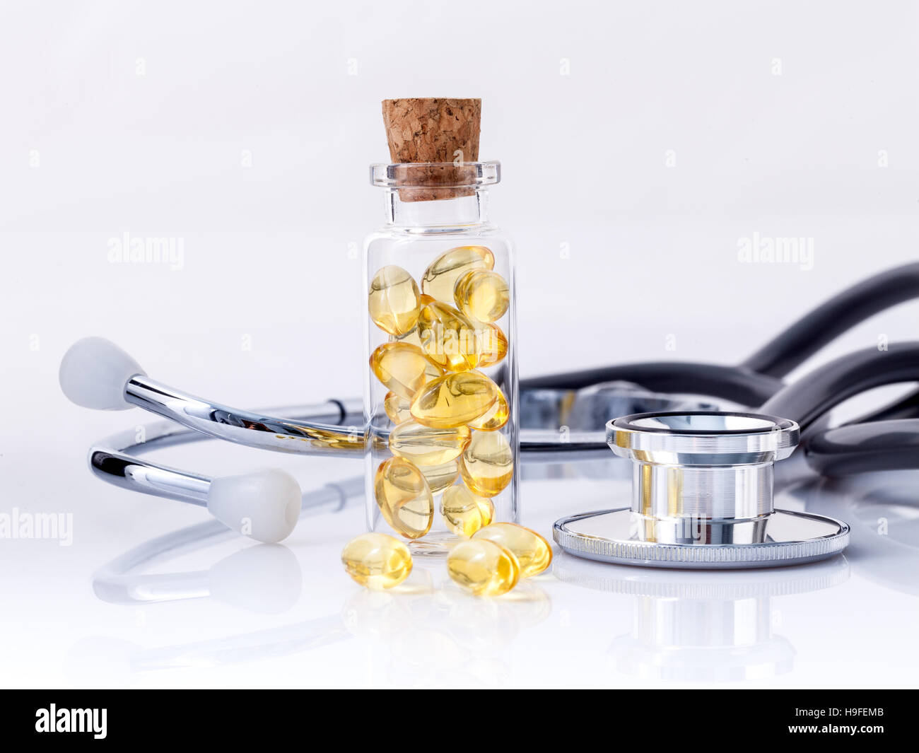 Leber Fischölkapseln in Flasche mit Stethoskop isolieren auf wh Stockfoto