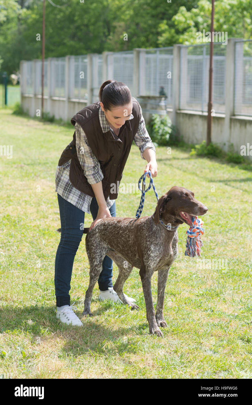 engagierte Mädchen Ausbildung Hund im Zwinger Stockfoto