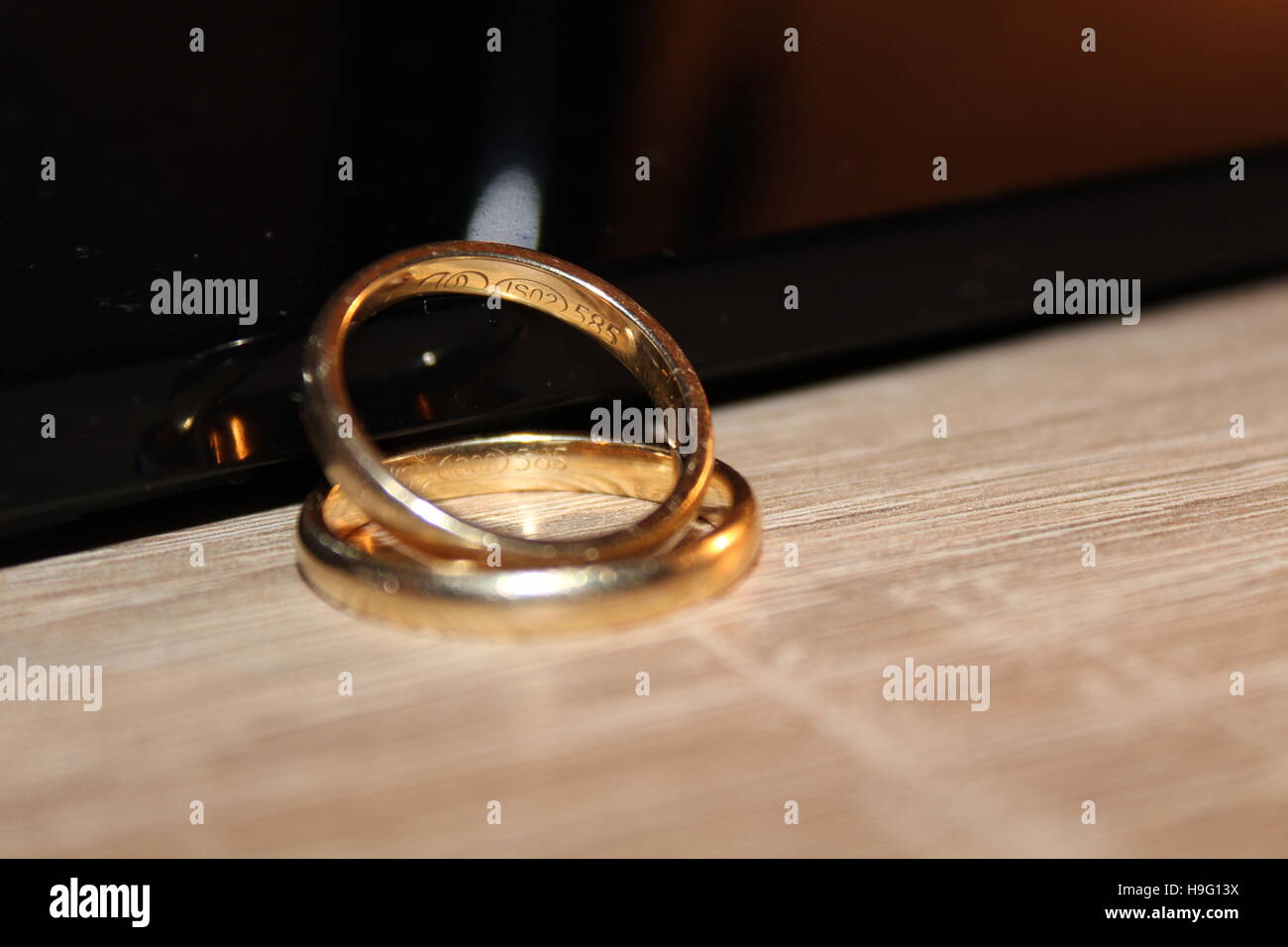 Hochzeit Goldringe zusammen übereinander auf einem Holztisch Stockfoto