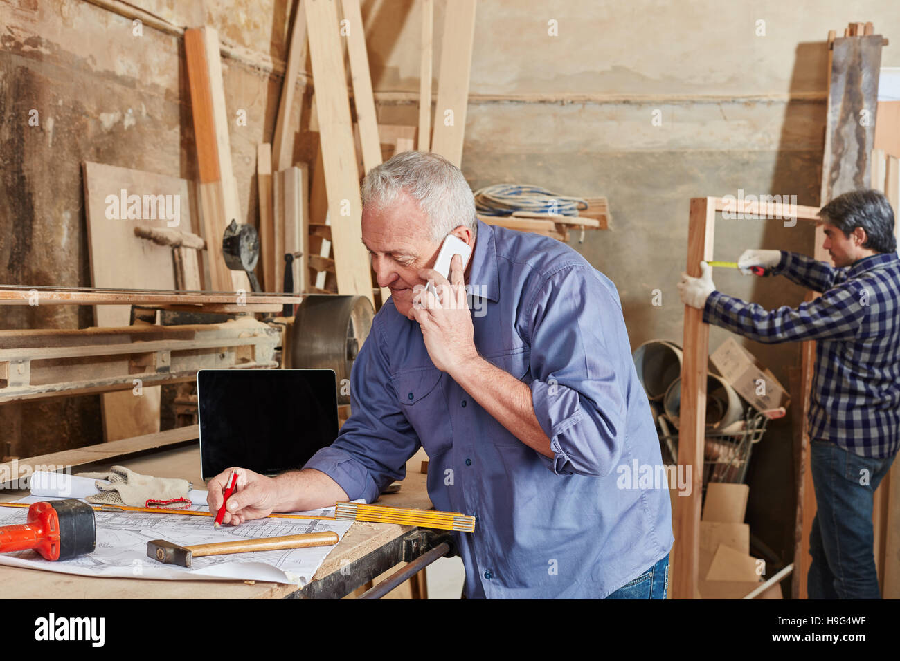 Senior executive Chef mit Smartphone bei Tischlerei Stockfoto