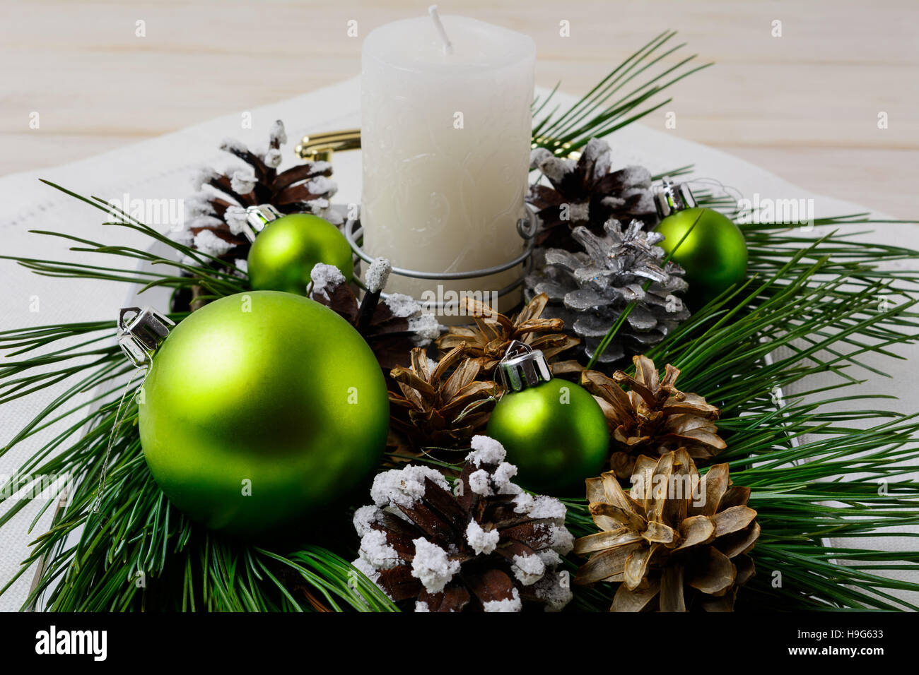 Grüne Weihnachtsschmuck und verschneiten Tannenzapfen Dekoration. Weihnachten Hintergrund mit glänzenden Kugeln. Stockfoto