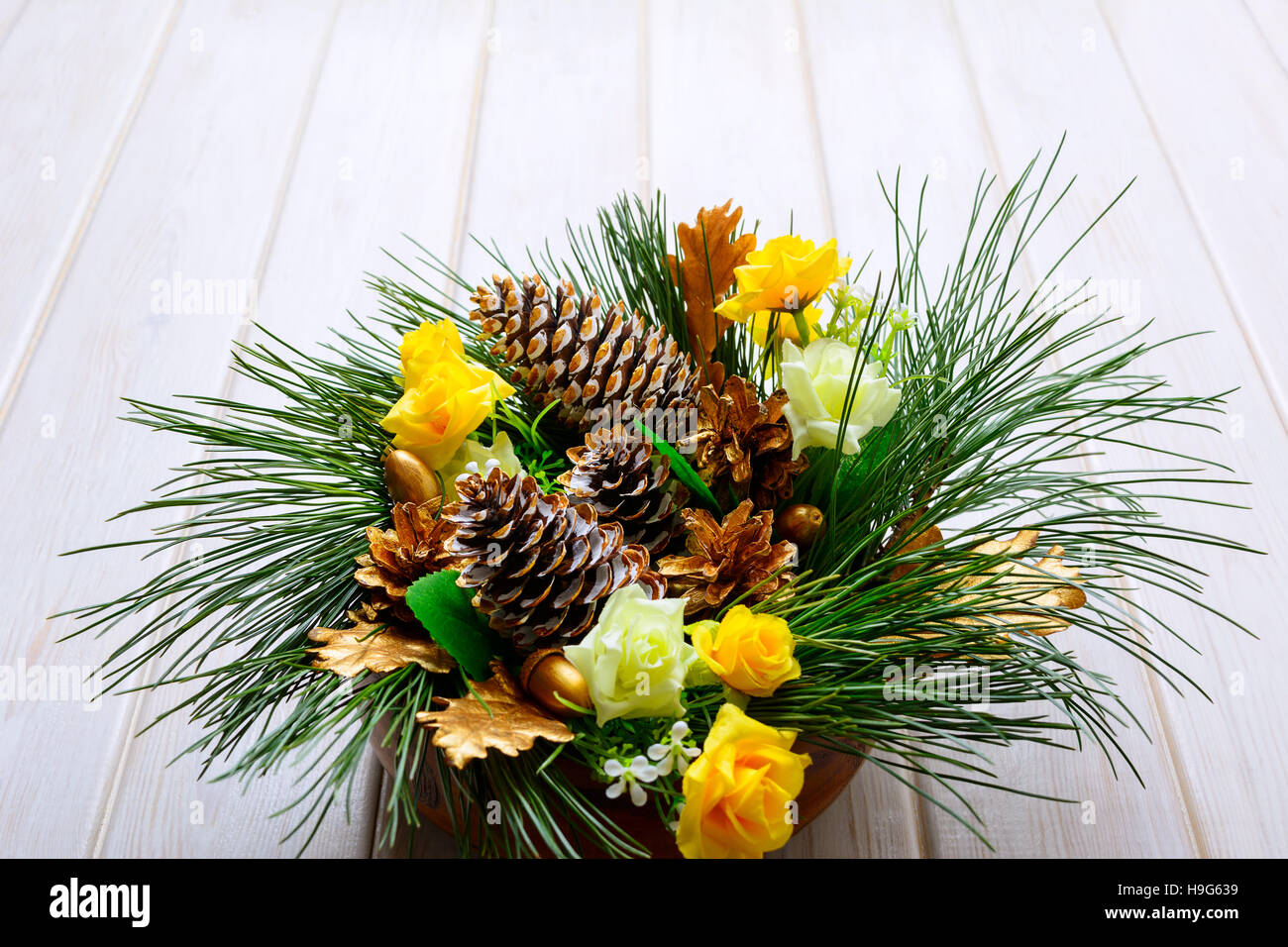 Weihnachten-Tafelaufsatz mit goldenen Tannenzapfen und Tannenzweigen. Weihnachten Hintergrund mit goldenen Dekor. Stockfoto