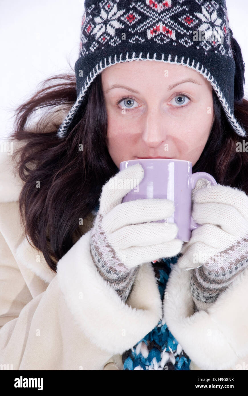 Junge Frau tragen Winterkleidung, trinken eine Tasse Tee Stockfoto