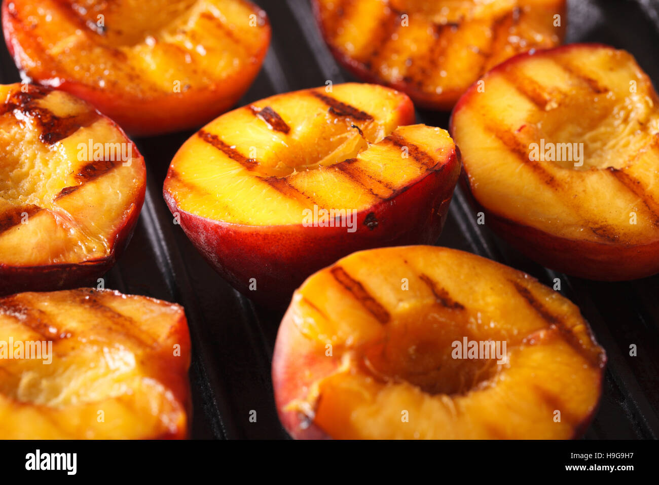 Frische Pfirsiche auf Grill-Makro. Horizontale Hintergrund Stockfoto