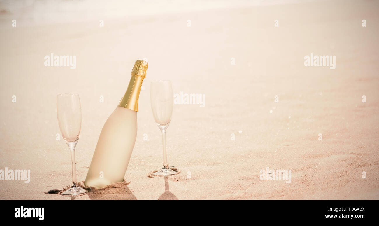 Sektgläser mit Flasche auf Sand am Strand Stockfoto