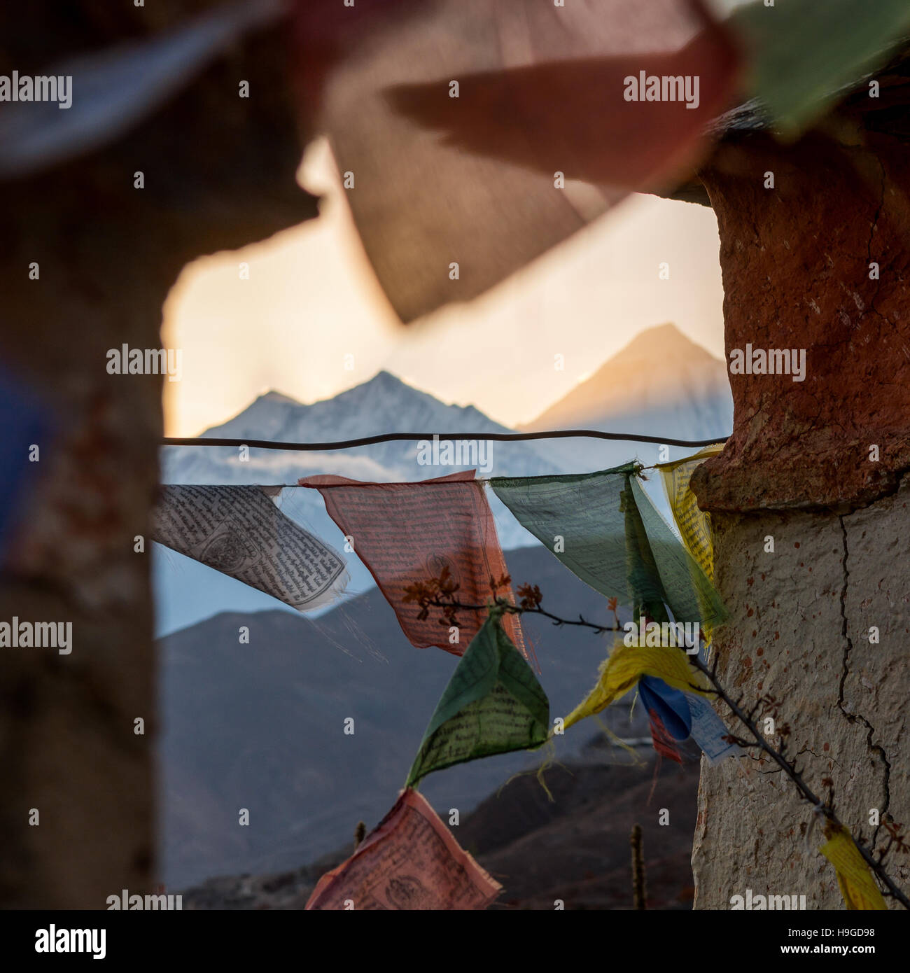 Berg Sonnenuntergang Thorugh ein Fenster des buddhistischen Fahnen. Stockfoto