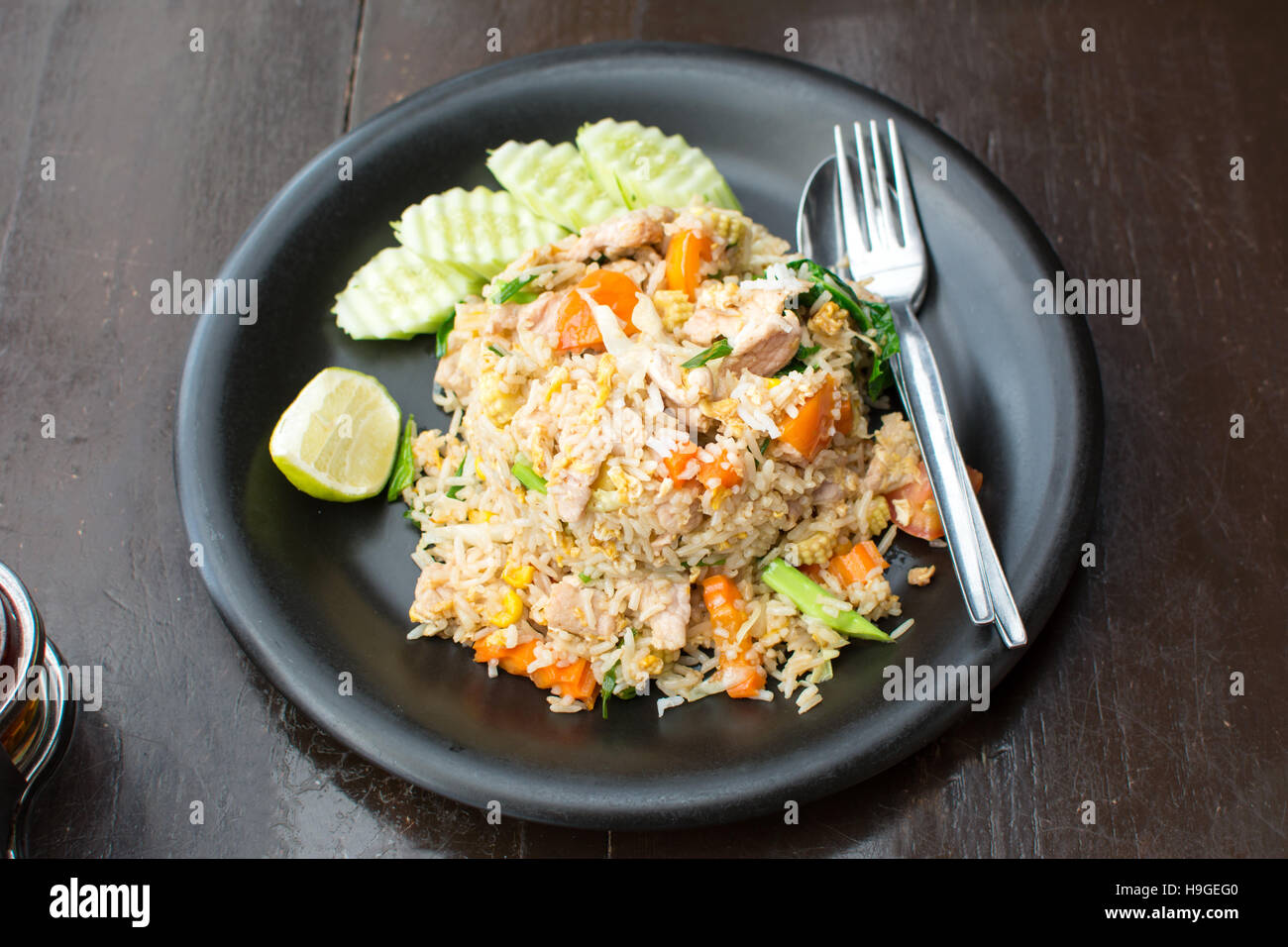 Gebratener Reis mit Fleisch und Gemüse auf einem Teller serviert Stockfoto