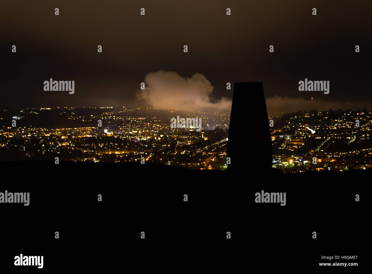 Silhouette trigonometrischen Punkt auf wenig Solsbury Hill. Nachtansicht der Stadt Bath mit Klappe für kartographische triangulation Stockfoto