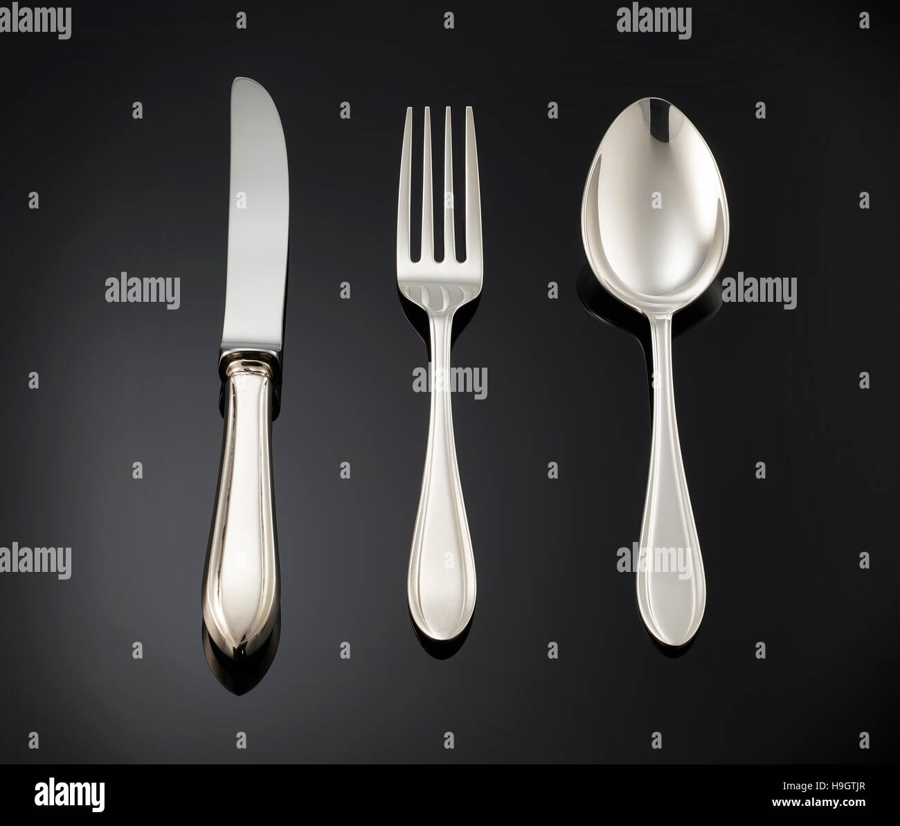 schöne silberne Bestecke auf schwarzem Hintergrund. Stockfoto