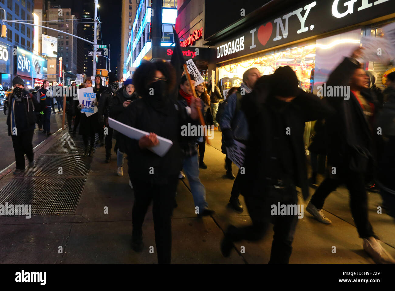 New York, USA. 23. November 2016. Aktivisten März durch den Times Square, New York City. Durch die jüngsten Ereignisse an der Standing Rock, North Dakota verärgert, Demonstranten März in Solidarität, in der Widerstand gegen den Bau der Dakota Zugang Pipeline. Stockfoto