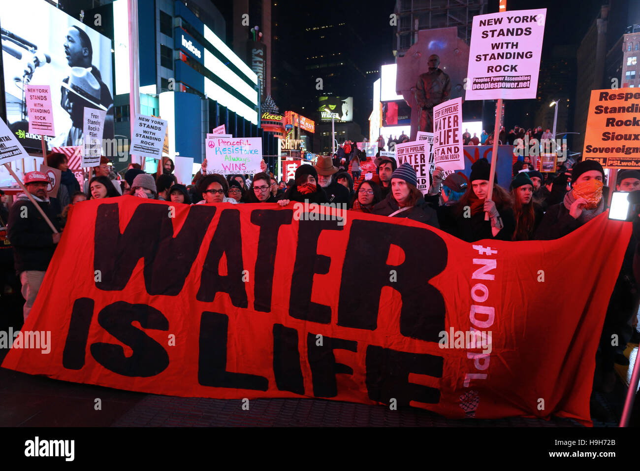 New York, USA. 23. November 2016. Aktivisten halten ein Banner, Wasser ist Leben, in Times Square, New York City. Demonstranten versammelt in Reaktion auf die jüngsten Ereignisse am Standing Rock, North Dakota; und das Gebäude der Dakota Zugang Pipeline zu widersetzen. Stockfoto