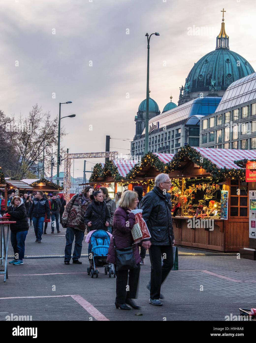 Berlin, Deutschland, 23. November 2016. Die Berliner Weihnachtzeit ist ein deutscher Weihnachtsmarkt rund um den historischen Neptunbrunnen (Neptunbrunnen) hinter Alexanderplatz gelegen. Die festliche hölzerne Marktstände befinden sich zwischen das Rotes Rathaus (Rotes Rathaus) und der Marienkirche. Eine festliche Atmosphäre erfolgt durch Drehorgel Musik, Glühwein, Stände verkaufen Kunsthandwerk, Brot in einer traditionellen Bäckerei und heißen Met gebacken aus Tonkrügen serviert. Besucher genießen eine Eisbahn und das 50 Meter hohe Riesenrad mit traditionellen Gondeln. Kinder genießen Sie Besuche zu den Streichelzoo, Pony zu befreien Stockfoto