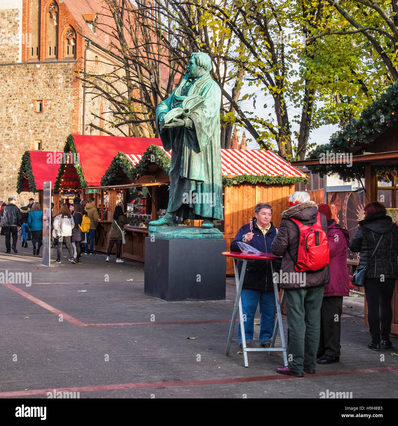 Berlin, Deutschland, 23. November 2016. Die Berliner Weihnachtzeit ist ein deutscher Weihnachtsmarkt rund um den historischen Neptunbrunnen (Neptunbrunnen) hinter Alexanderplatz gelegen. Die festliche hölzerne Marktstände befinden sich zwischen das Rotes Rathaus (Rotes Rathaus) und der Marienkirche. Eine festliche Atmosphäre erfolgt durch Drehorgel Musik, Glühwein, Stände verkaufen Kunsthandwerk, Brot in einer traditionellen Bäckerei und heißen Met gebacken aus Tonkrügen serviert. Besucher genießen eine Eisbahn und das 50 Meter hohe Riesenrad mit traditionellen Gondeln. Kinder genießen Sie Besuche zu den Streichelzoo, Pony zu befreien Stockfoto