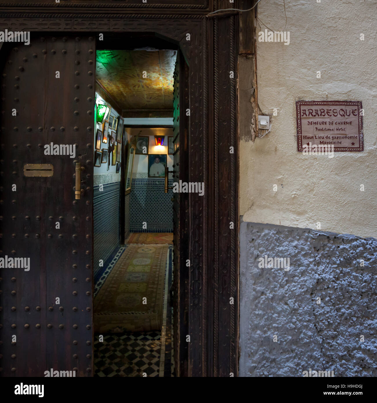 Eingang des Riad Arabesque, Fès, Marokko. Ein dunkler Eingang an einer verbietenden Wand lässt sogar Zweifel aufkommen, ob sich die Tür öffnet, wenn man die Glocke läutet Stockfoto