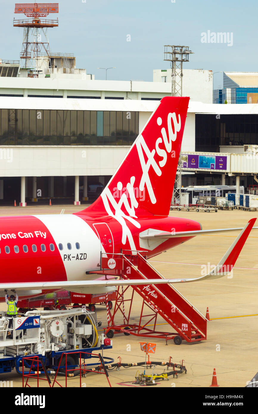 Treppe-Auto am Heck des roten Flugzeug der Air Asia vor Kontrollturm am Flughafen Don Mueang. Vertikal Stockfoto