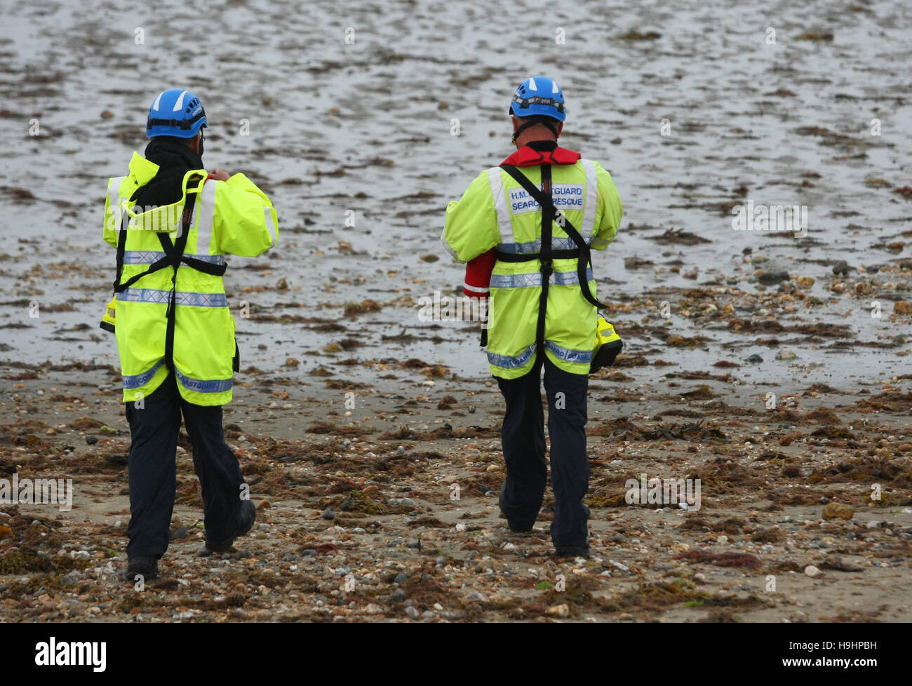 HM Coastguard Suche und Rettung Offiziere Fuß am Strand Stockfoto