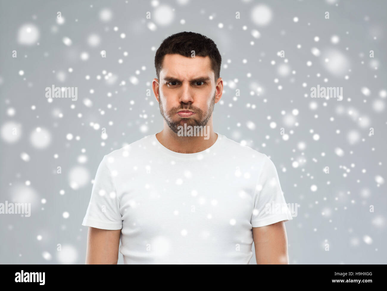 Mann mit lustigen wütendes Gesicht über Schnee Hintergrund Stockfoto